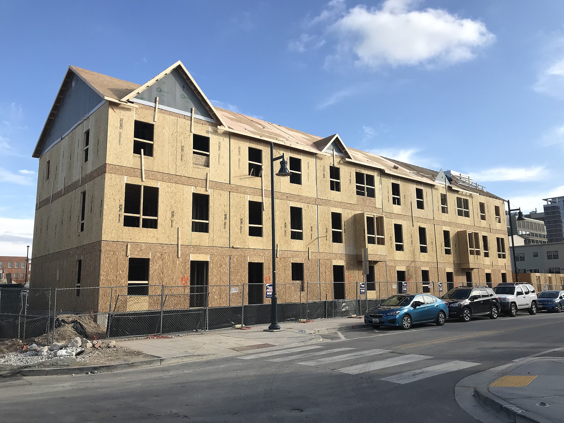 Row of three-storey wood-frame townhouses under construction with sheathing exposed