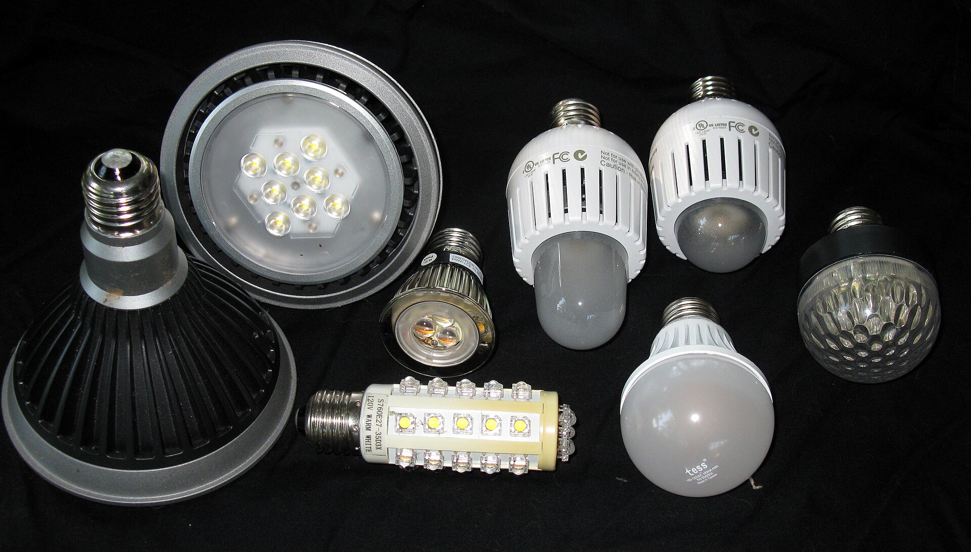 Assortment of LED light bulbs in different shapes and base sizes on a black background