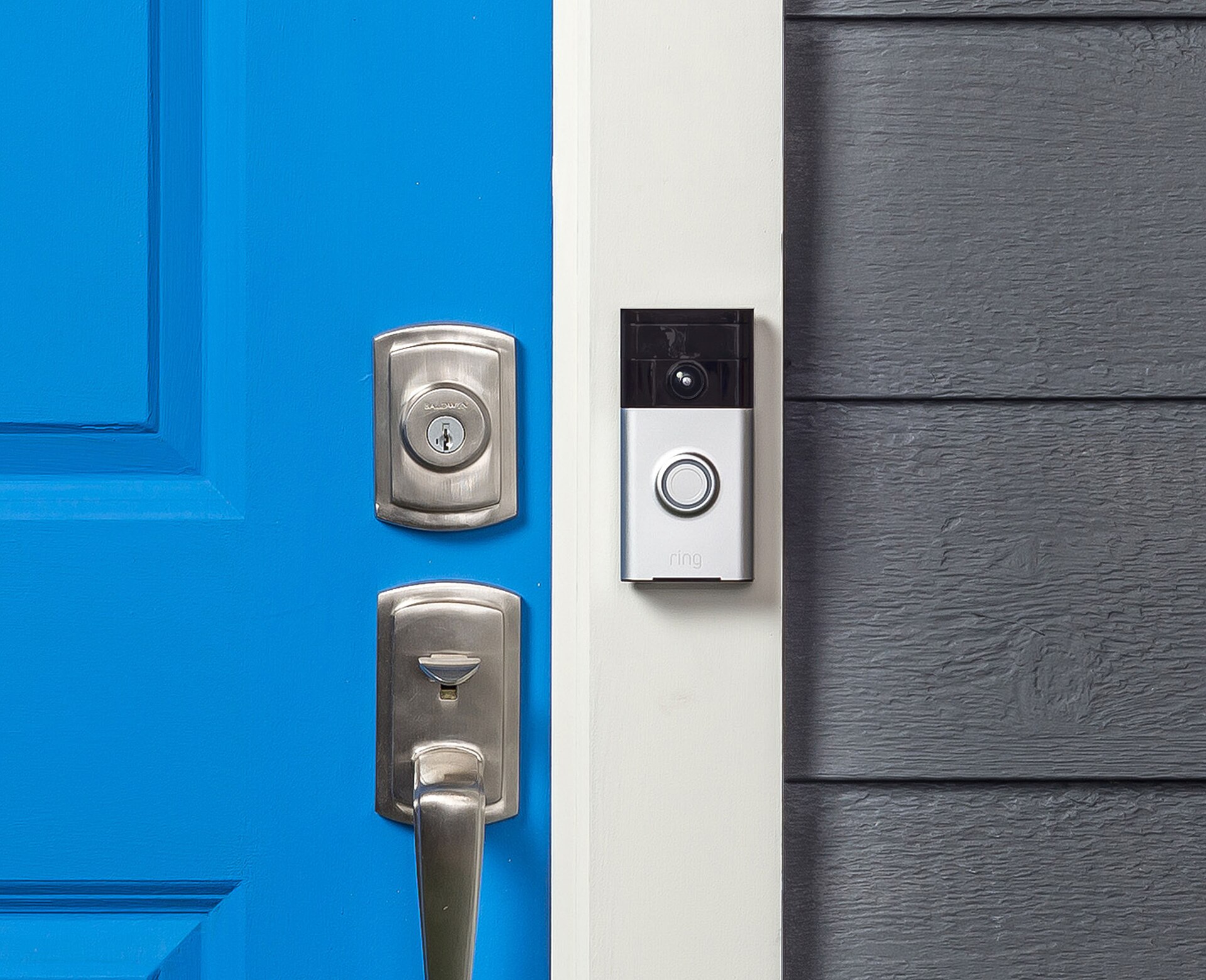 Video doorbell mounted beside a blue front door with a keyed deadbolt and handle