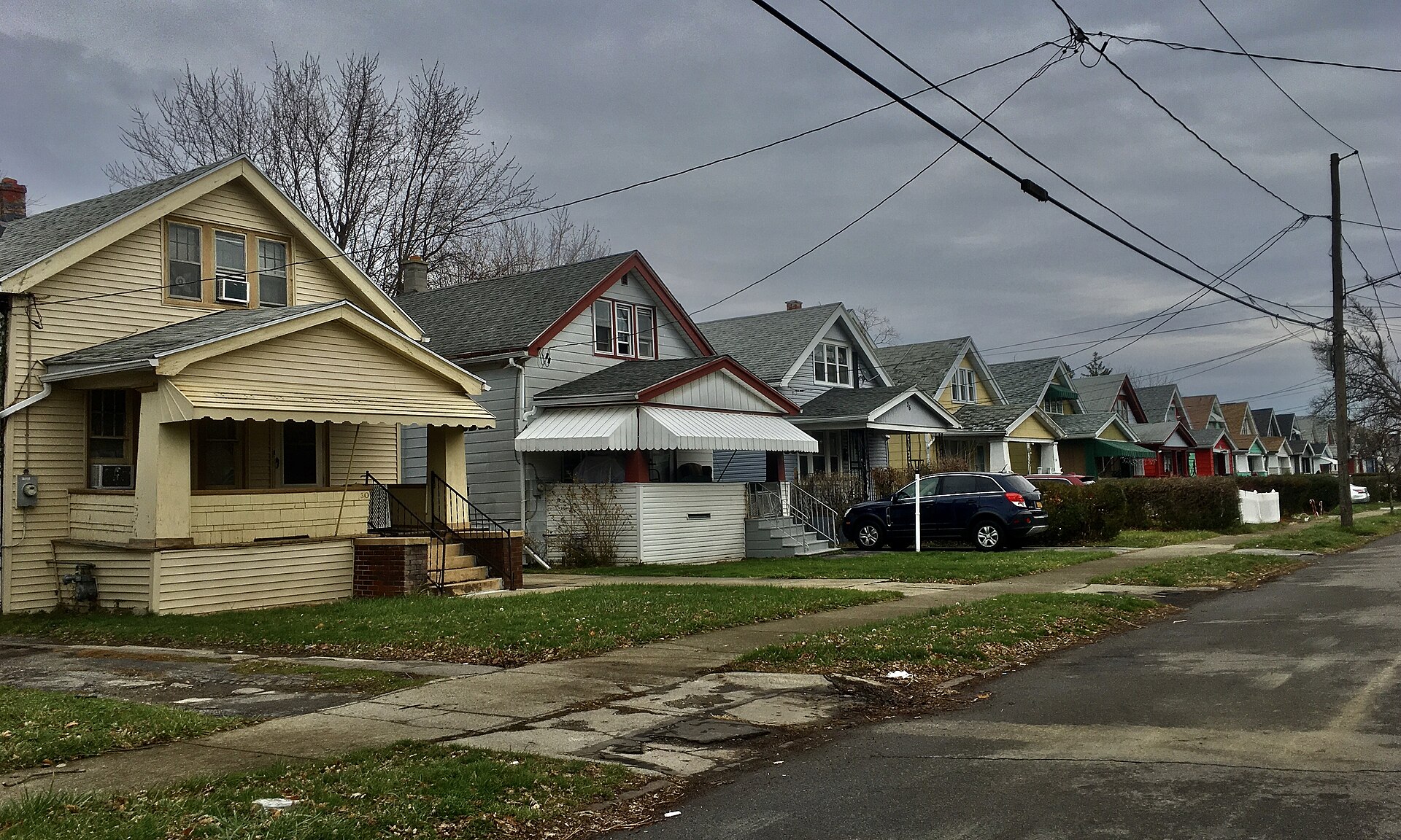 Row of similar Craftsman-style bungalows with front porches along a residential street